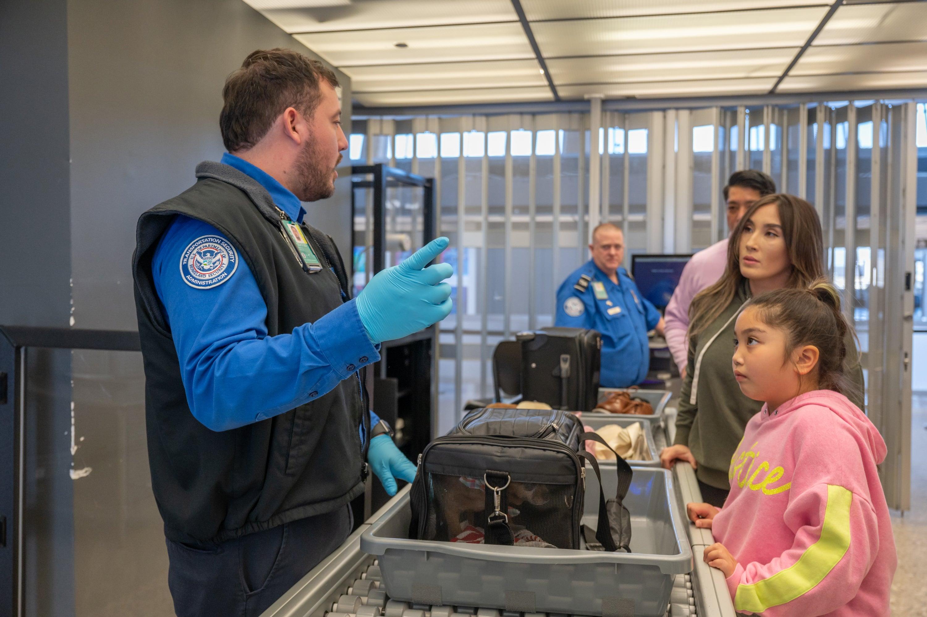 DULLES, VA- FEBRUARY 24: TSA agent Joshua Antelo  explains to t