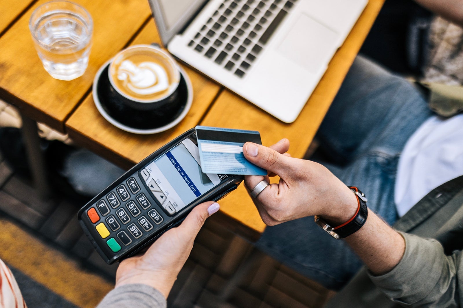 Smart casual young guy is paying with credit card
