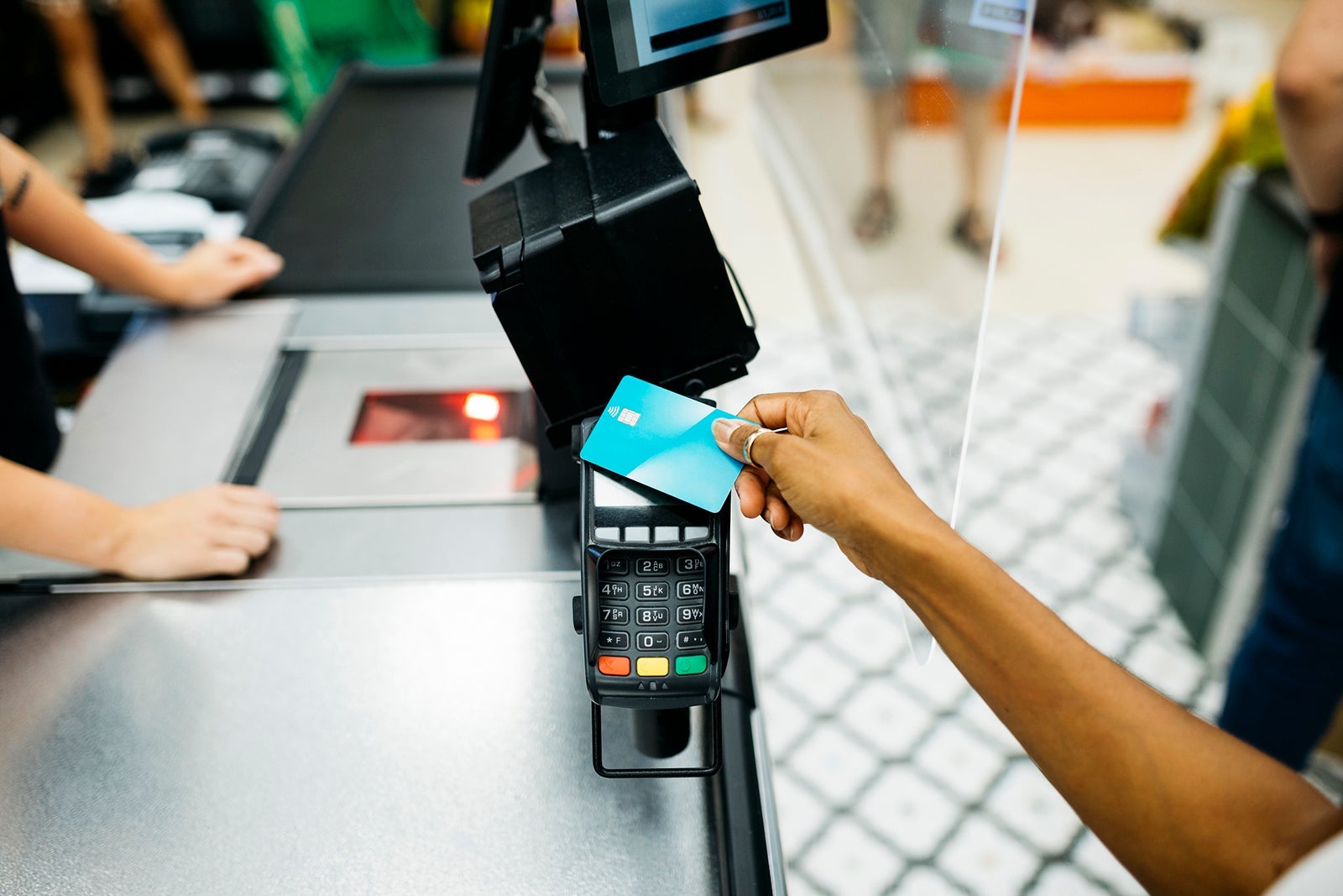 Close up of a hand paying with a credit card in a supermarket