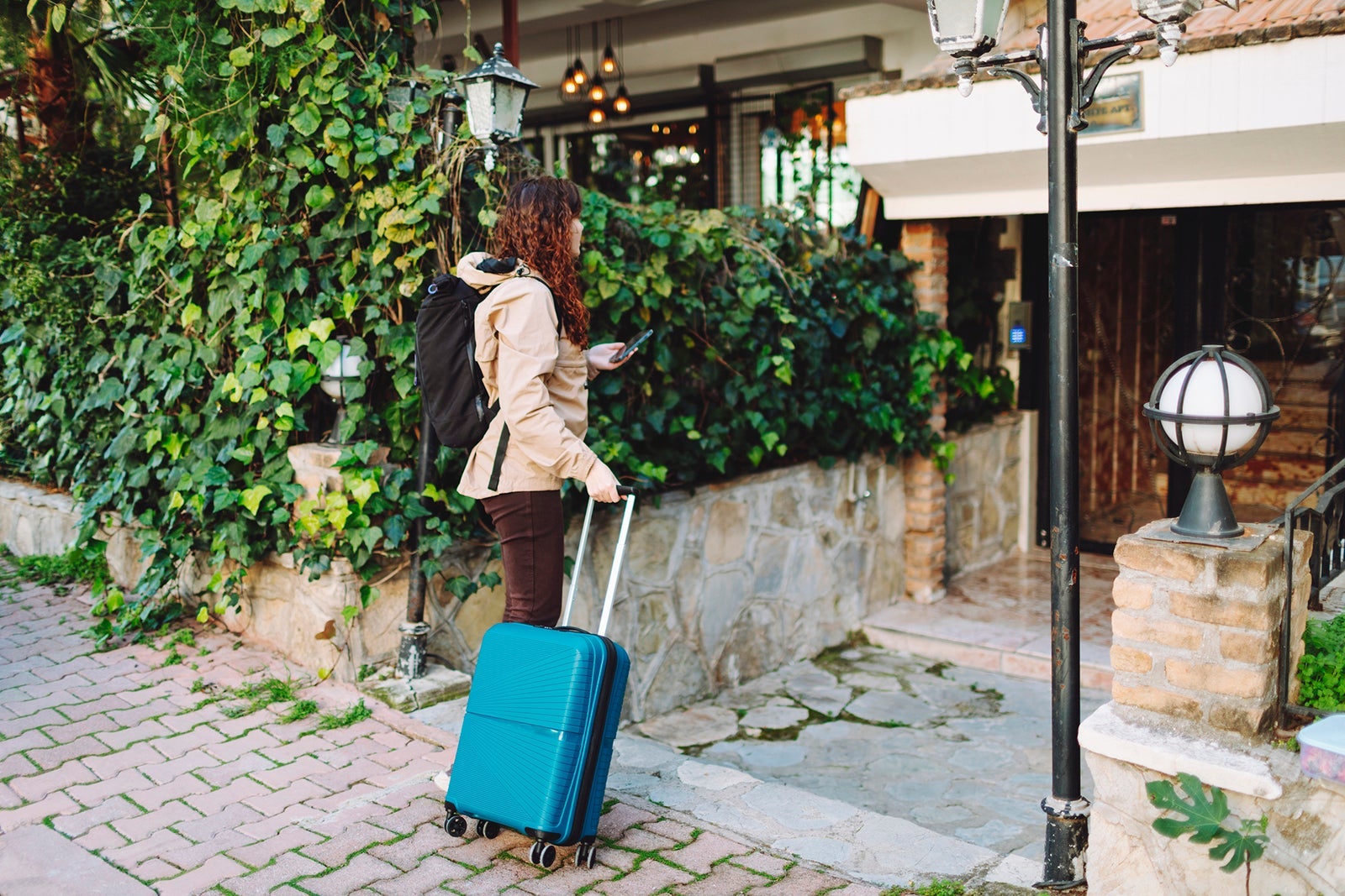 Young woman with suitcase searching hotel