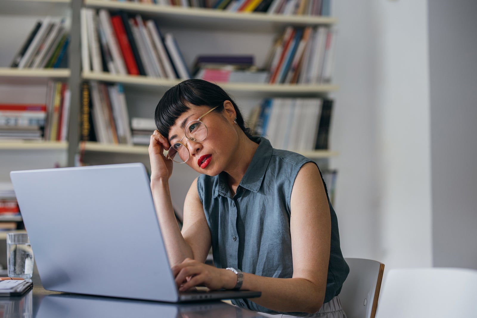 A Frustrated Beautiful Asian Businesswoman With Glasses Using Her Computer While Working In The Office